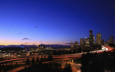 Vehicles light trails on road in illuminated city