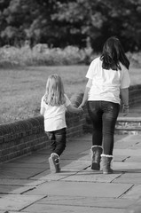 Two Sisters Walking Together While Holding Hands in Black and White