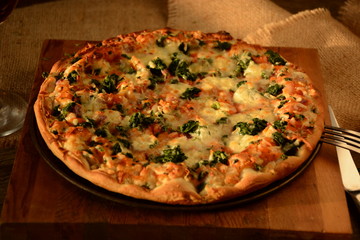 Vegetable pizza with spinach and mozzarella cheese on a wooden background
