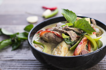 Green curry with beef in a black bowl, Thai food