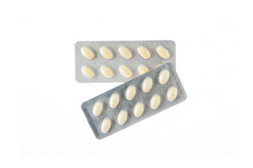 two plates of yellow tablets on white isolated background