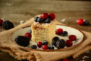 Piece of cake napoleon on a plate with sweet fresh berries