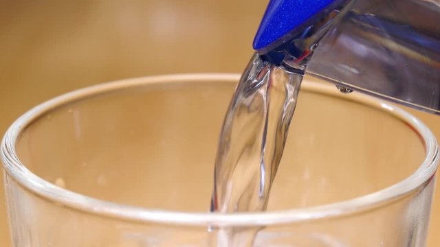 Detailed close up of water pouring into drinking glass. Hydration concept