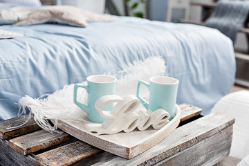Valentine's Day! On a tray in the form of a heart, two mugs of blue and the word love