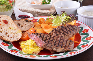 Closeup of beefsteak  with french fries and vegetables   