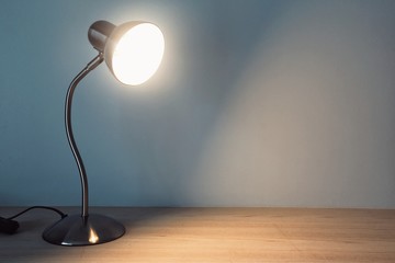 table lamp with light-on on the wooden table in vintage style.