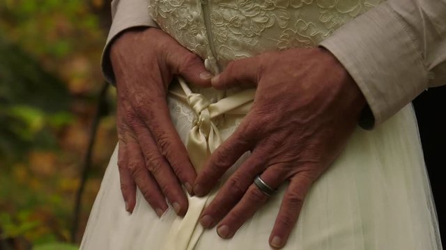 groom with his hands against brides backside in the forest 4k