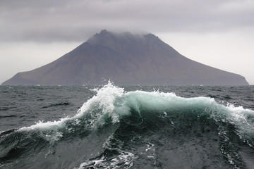 Sea wave on the background of the Kuril Islands © vasilevich