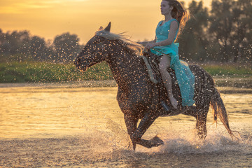Girl riding horse on water surface