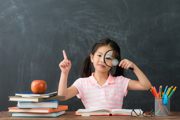 beautiful female kid student showing magnifier