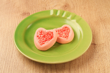 Obraz na płótnie Canvas Strew berry heart cookies on green plate 