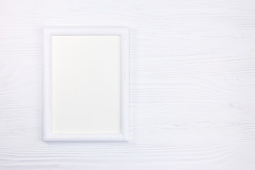 empty white wooden picture frame on white wooden background with copy space