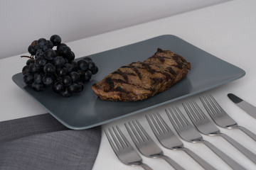 A piece of juicy meat on a gray plate.