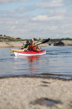 Active senior paddling a sea kayak on Georgian Bay, Ontario, Canada.