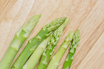 fresh asparagus on wood cutting board background