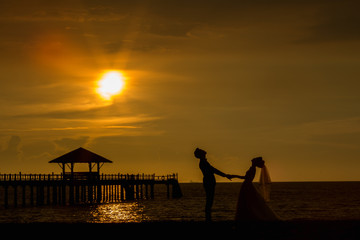 Bride and groom honeymoon on the beach