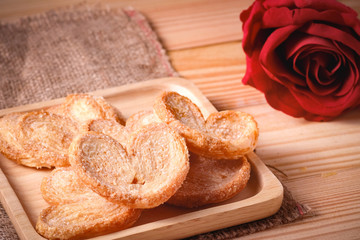 Pie a butterfly, heart shaped patty crispy on wooden plate