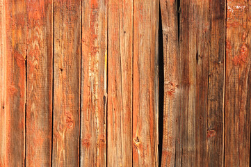 Old red wooden textured background with wall crack.