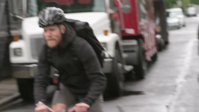 Handheld shot of male commuter riding bicycle falls off on street