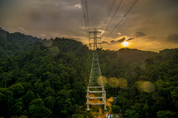high voltage power line through a valley inside deep jungle