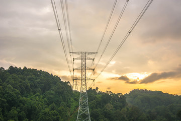 high voltage power line through a valley inside deep jungle