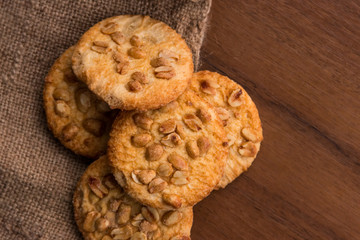 Sweet cookies with peanuts on wooden table. Top view