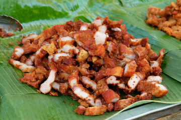 Sliced crispy deep fried pork on banana leaf for selling