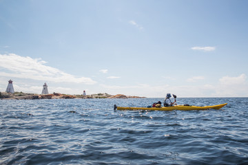 Naklejka premium A group of active seniors on a guided sea kayak trip on the Great Lakes in Ontario, Canada.