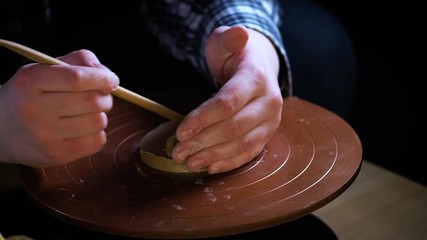 Potter special tools handles clay. Master crock. The creative process in the studio. Twisted potter's wheel. Man creates a work of art. The ability to create beauty. Master kneads the clay