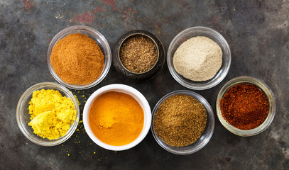 Variety of colorful spices on metal rusty background, top view