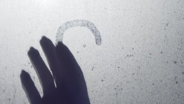 The glass of the window is swamped. Young girl with forefinger draws a symbol of love and heart. St. Valentine's Day