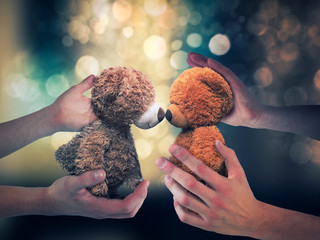 Human hands holding kissing plush bears