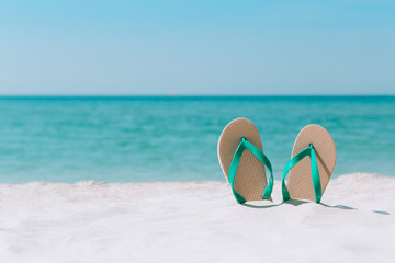Fototapeta na wymiar Ocean landscape And sandals on the beach. Welcome summer