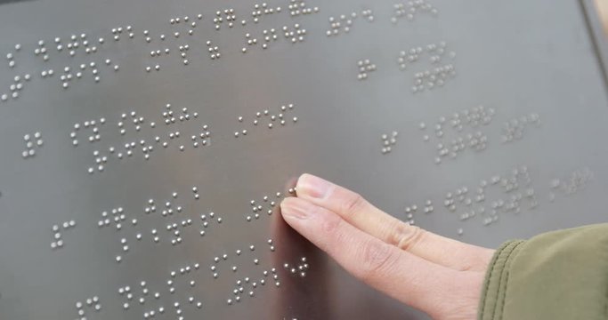 Blind reading on Braille at outdoor directory