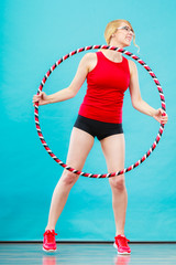 Fit woman with hula hoop doing exercise