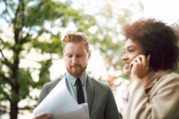 Happy business couple using smart phone outdoors