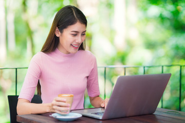 Asian lady working with computer note book and drink a coffee