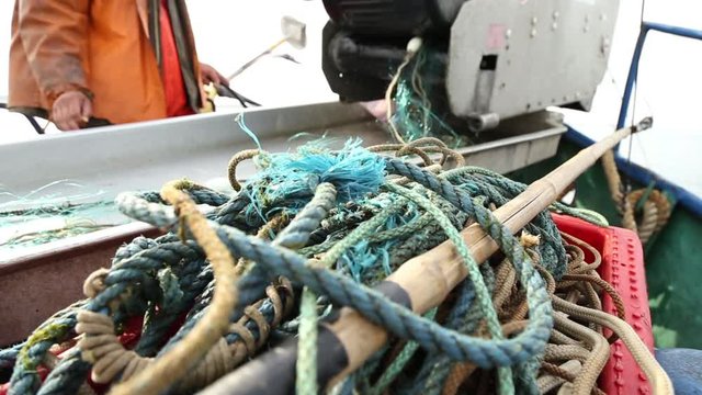 Fishermen pull out fishing nets on boat