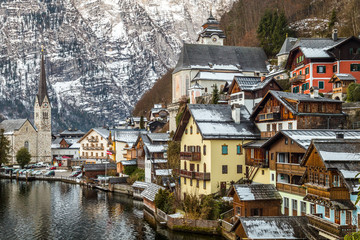 Fototapeta na wymiar Lake view at the tower and houses of Hallstatt, famous picturesque village in Austria