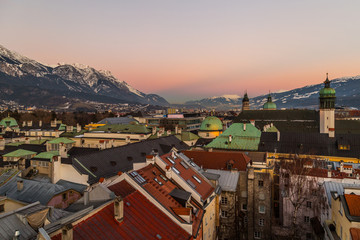 Rooftop cityscape view of Innsbruck, Austria at sunset with mountains and colourful houses