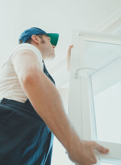 Professional handyman installing window at home.