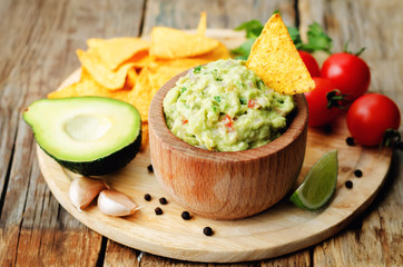 Guacamole with corn chips and ingredients to prepare it