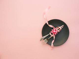 Party table setting. Top view, flat lay over pink background. Menu for restaurant, invitation for dinner or wedding elegant place setting