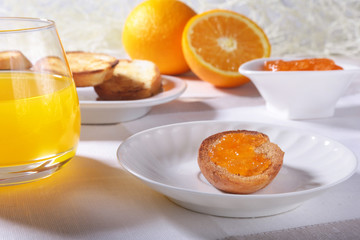 Morning Breakfast set with orange jam on bread toast and juice in glass.