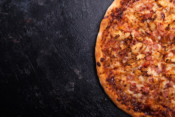 Top close up view of fresh baked pizza on dark wooden background with copy space available