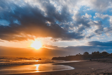 Sunset on black sand beach, clody Sky. Indian Ocean, Indonesia Bali.