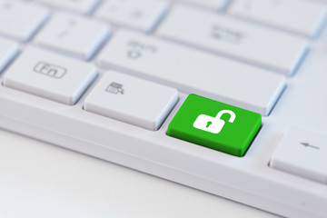 Green key with open padlock icon symbol on laptop keyboard