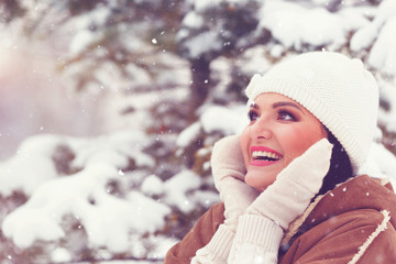 Portrait of beautiful woman in a winter snowy scenery. Selective focus, blank space 