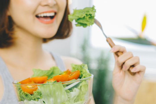 Beautiful Young Asian Woman eating fresh vegetable salad. Loosing Weight concept