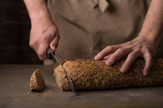 Man cutting a freshly baked loaf of bread